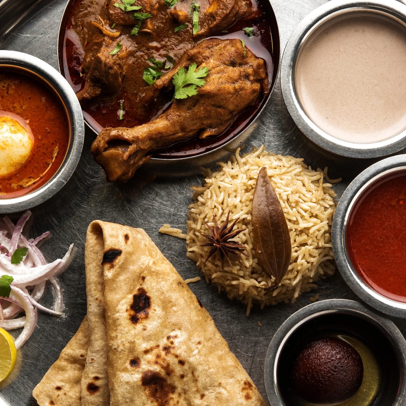 Traditional Kolhapuri thali spread with rassa, rice and bhakri