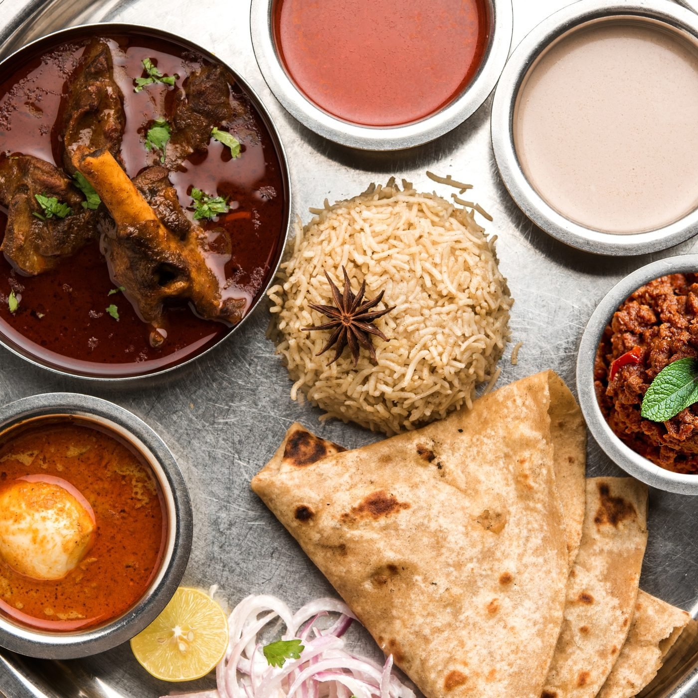 Traditional Kolhapuri mutton thali with tambda rassa, pandhra rassa and bhakri